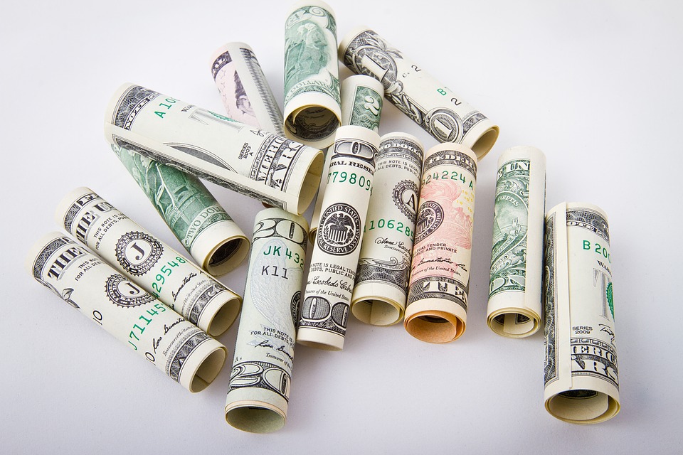dollar bills being rolled